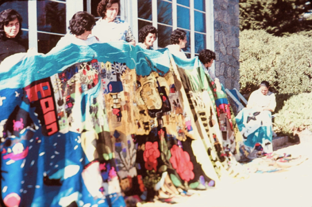 The Collective Embroidery Grupo de bordadoras sosteniendo en altura el Bordado Colectivo finalizado para mostrar su envergadura en Isla Negra