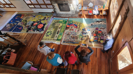 The Collective Embroidery Vista general de bordadoras y familiares observando piezas del Bordado Colectivo tras su reaparición después de 50 años