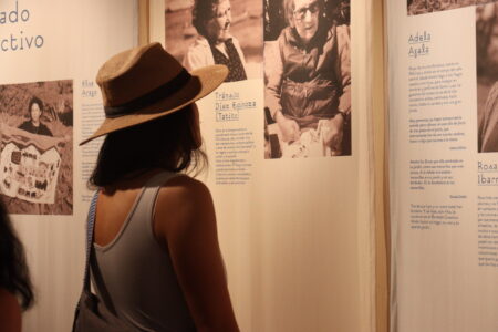 The Collective Embroidery Visitante consultando la información biográfica y el registro de autoría de las bordadoras en la sala del Museo Baburizza